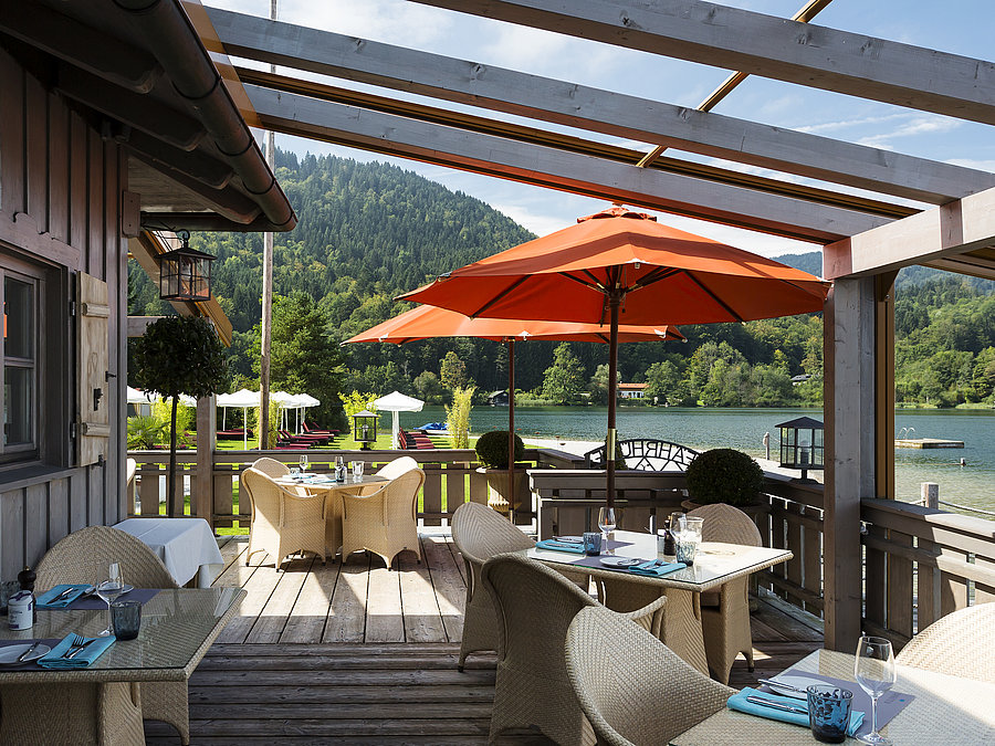 Althoff Seehotel Überfahrt Restaurant Fährhütte Terrasse mit Sonnenschirmen und gedeckten Tischen