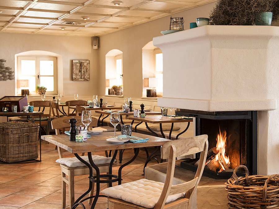 Althoff Seehotel Überfahrt Restaurant Fährhütte Innenbereich mit kamin und gedeckten Tischen