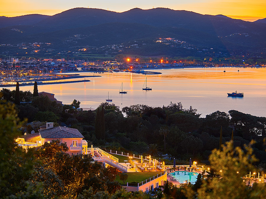 Althoff Villa Belrose in St. Tropez Aussenansicht bei Nacht mit Meerblick und Schiffen im Sommer