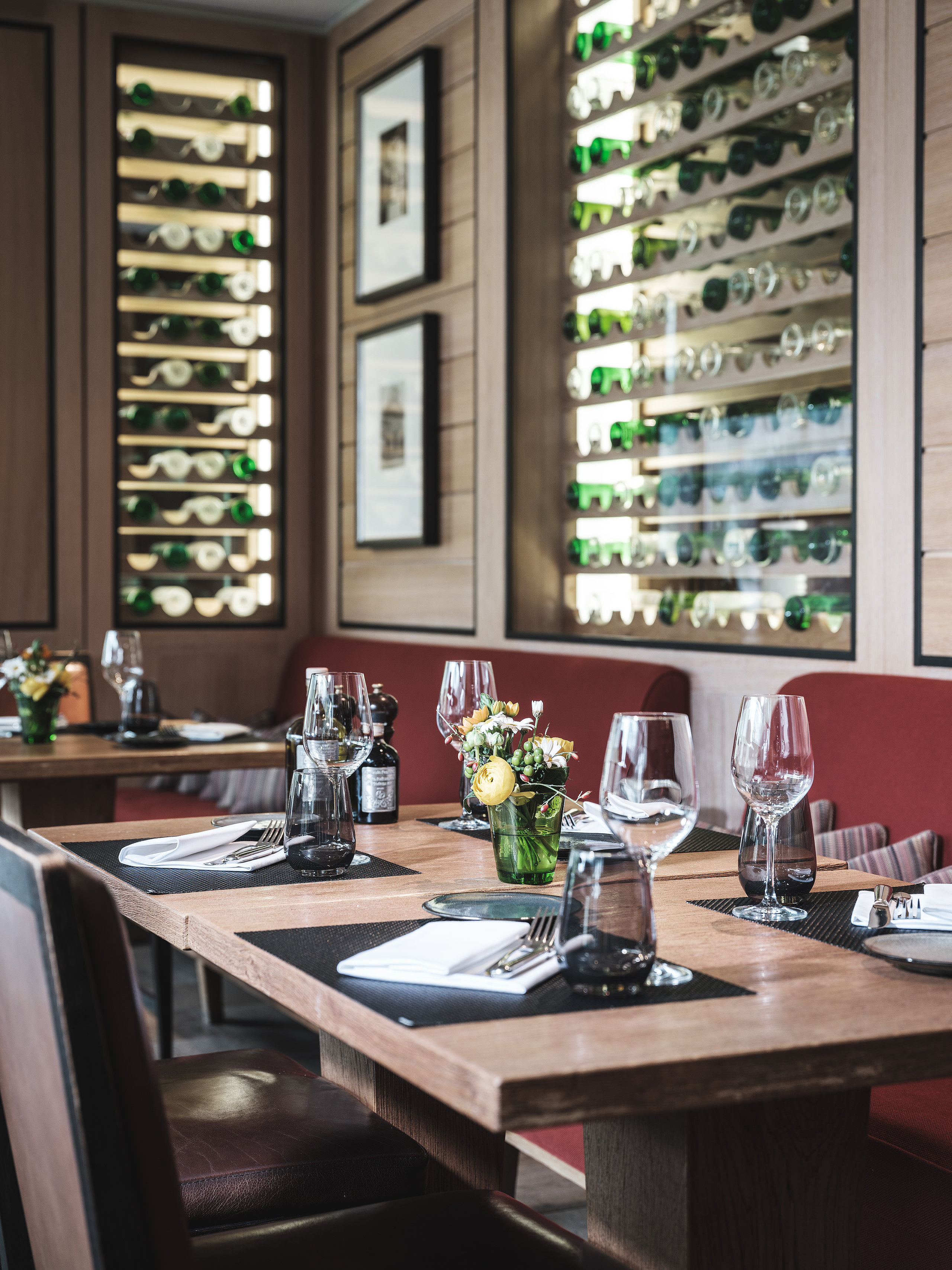 Althoff Seehotel Überfahrt Restaurant Il Barcaiolo Innenbereich mit gedecktem Tisch und Weinregal
