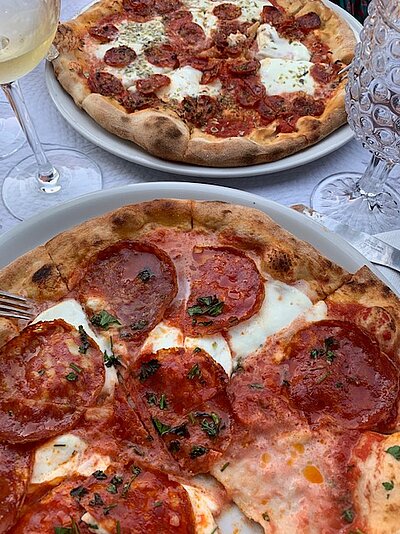 Pizza mit Ventricina-Salami im Hintergrund mit scharfer Soppresa-Wurst